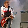 Simon Triebel spielt eine rote E-Gitarre auf der Bühne, dahinter Bühnennebel und Verstärker